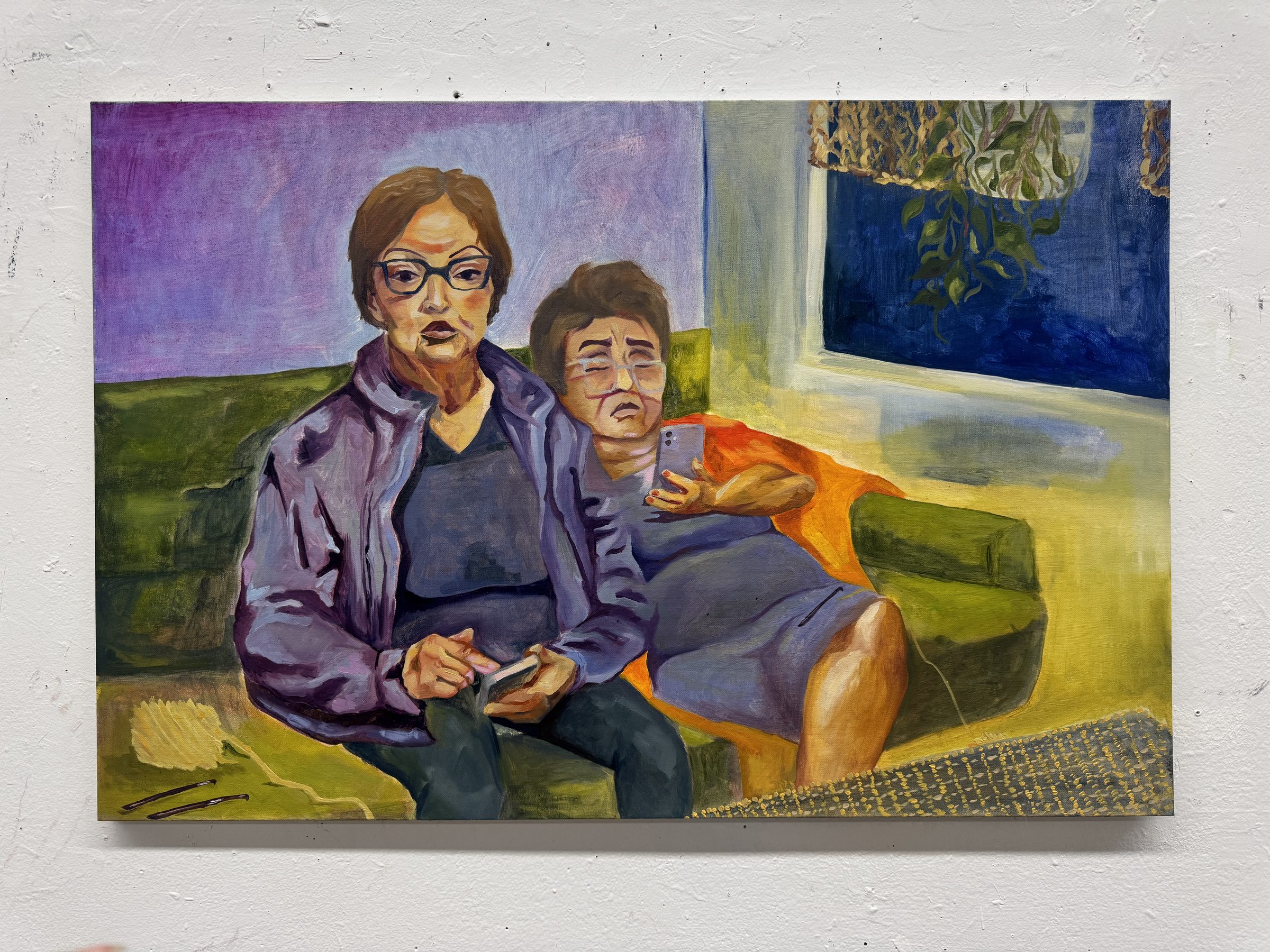 Oil painting of two women seated on a green couch in a violet and yellow room